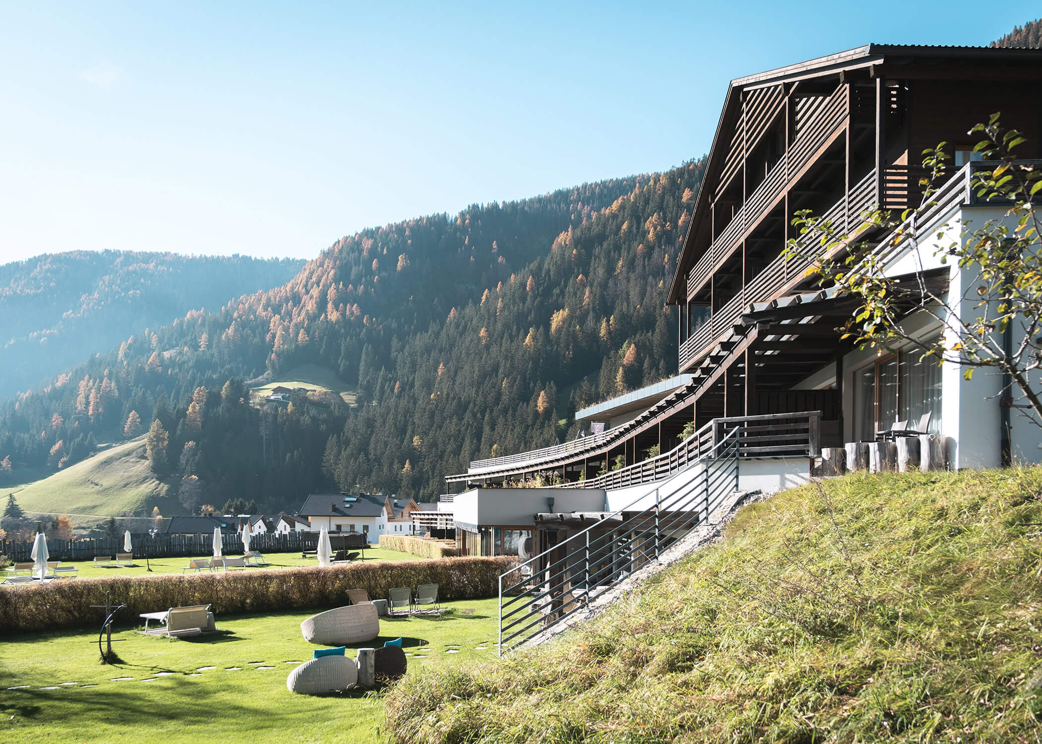 Modernes Hotel mit Balkonen und Blick auf eine sonnige Wiese und an klaren Tagen auf bewaldete Berge. - Hotel La Casies Mountain Living