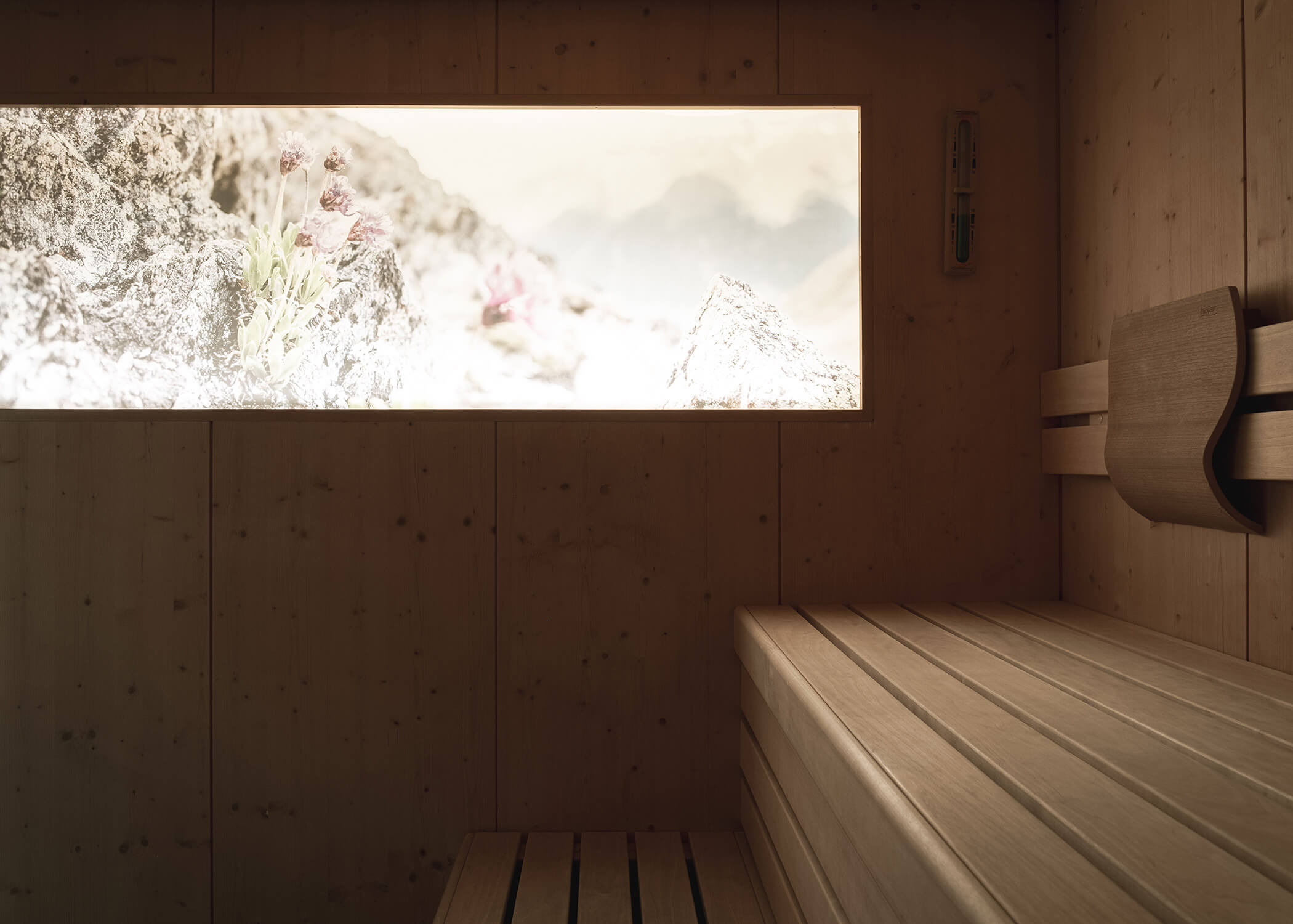 Eine moderne Holzsauna mit einem Fenster, das den Blick auf eine felsige Berglandschaft freigibt. - Hotel La Casies Mountain Living