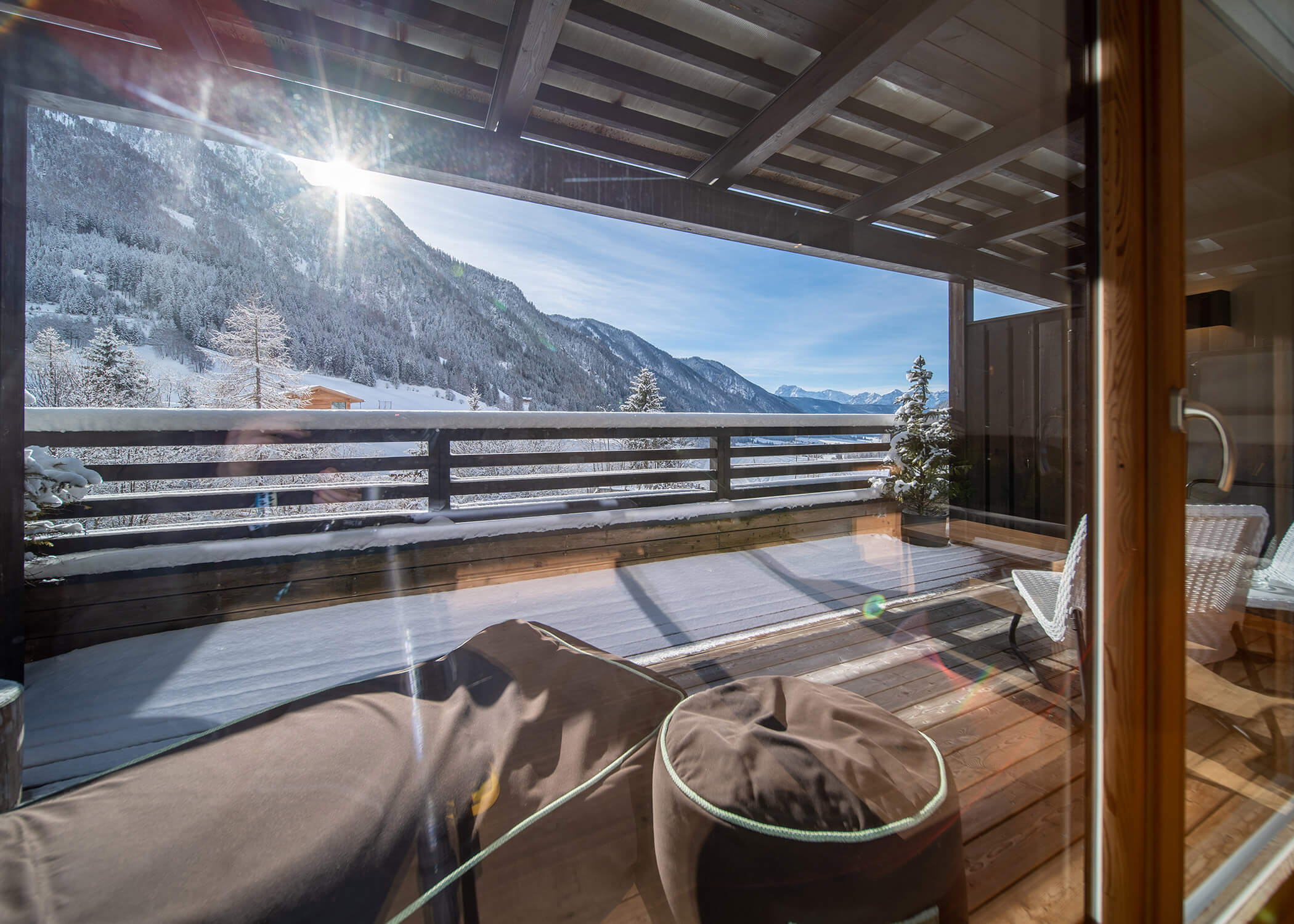 Sonniger Bergblick vom Holzbalkon mit Liegestühlen und schneebedeckter Landschaft. - Hotel La Casies Mountain Living
