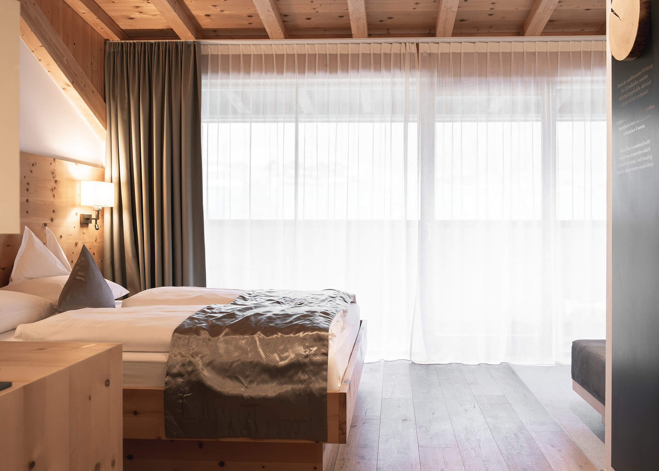 Minimalistisches Hotelzimmer mit Holzakzenten, einem Doppelbett, transparenten Vorhängen und sanftem Tageslicht. - Hotel La Casies Mountain Living