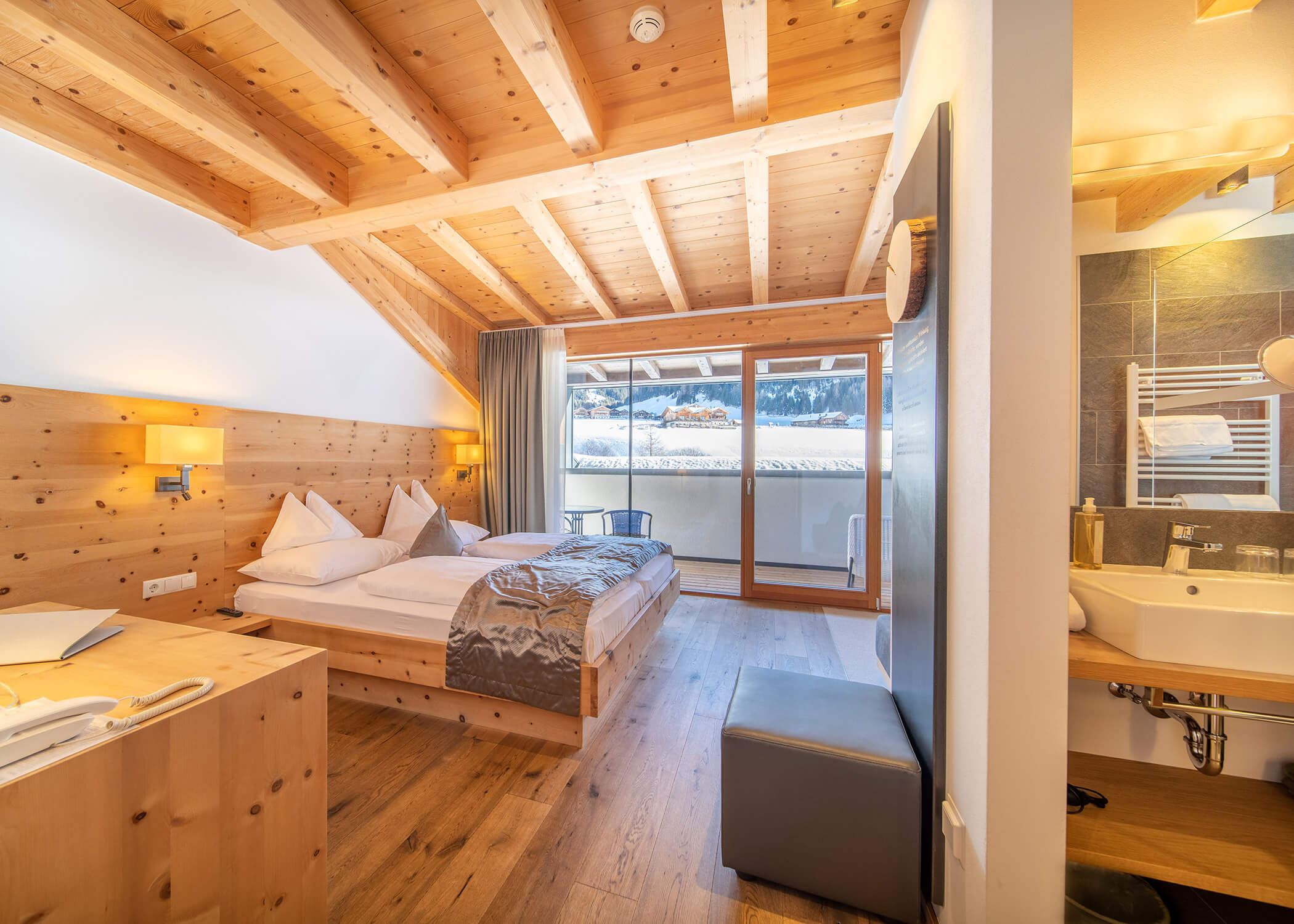 Gemütliches Hotelzimmer mit Holzausstattung, Doppelbett, Schreibtisch, Balkon und modernem Bad. - Hotel La Casies Mountain Living