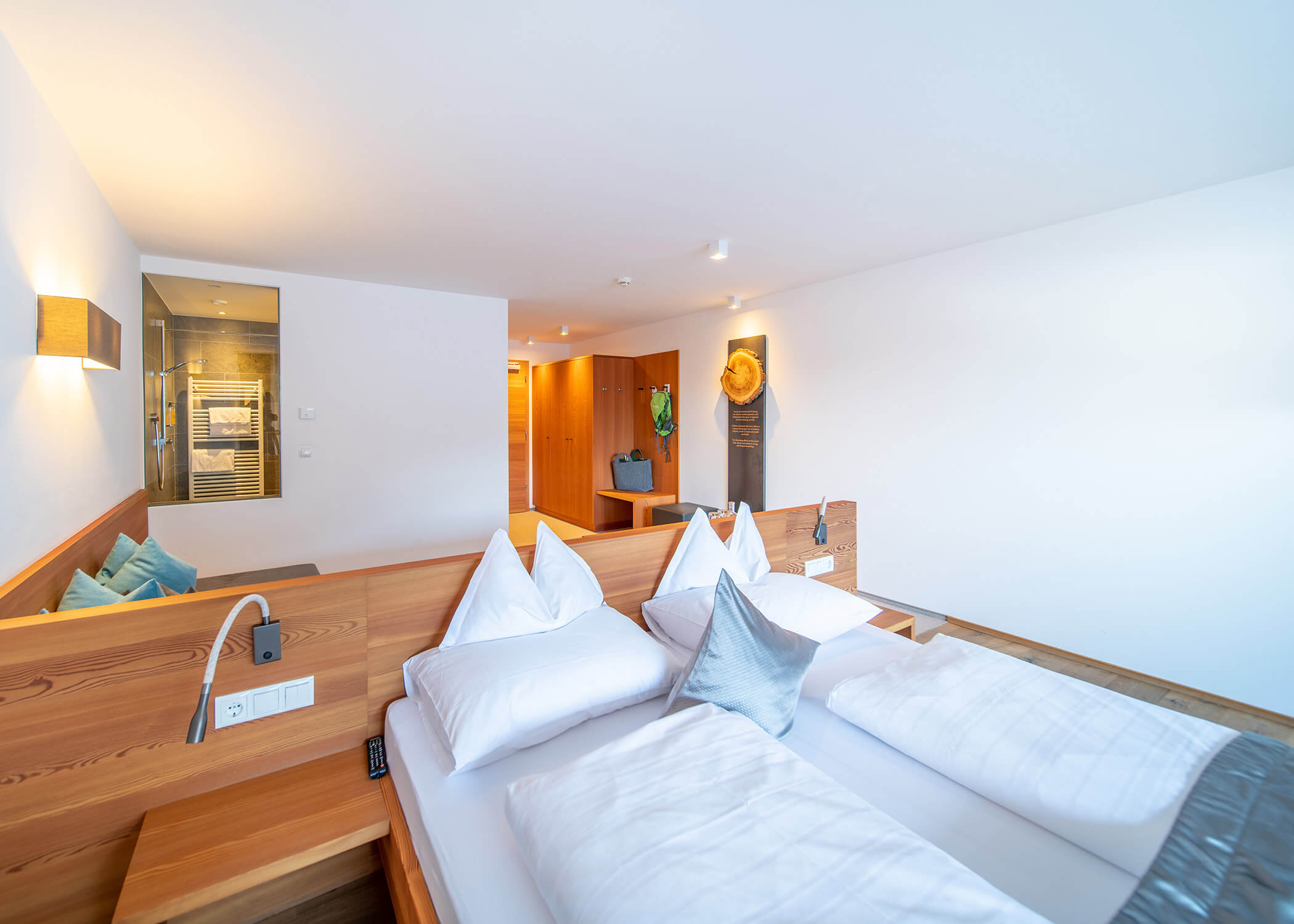 Helles Hotelzimmer mit Holzmöbeln, Doppelbett, Sitzecke und moderner Einrichtung. - Hotel La Casies Mountain Living